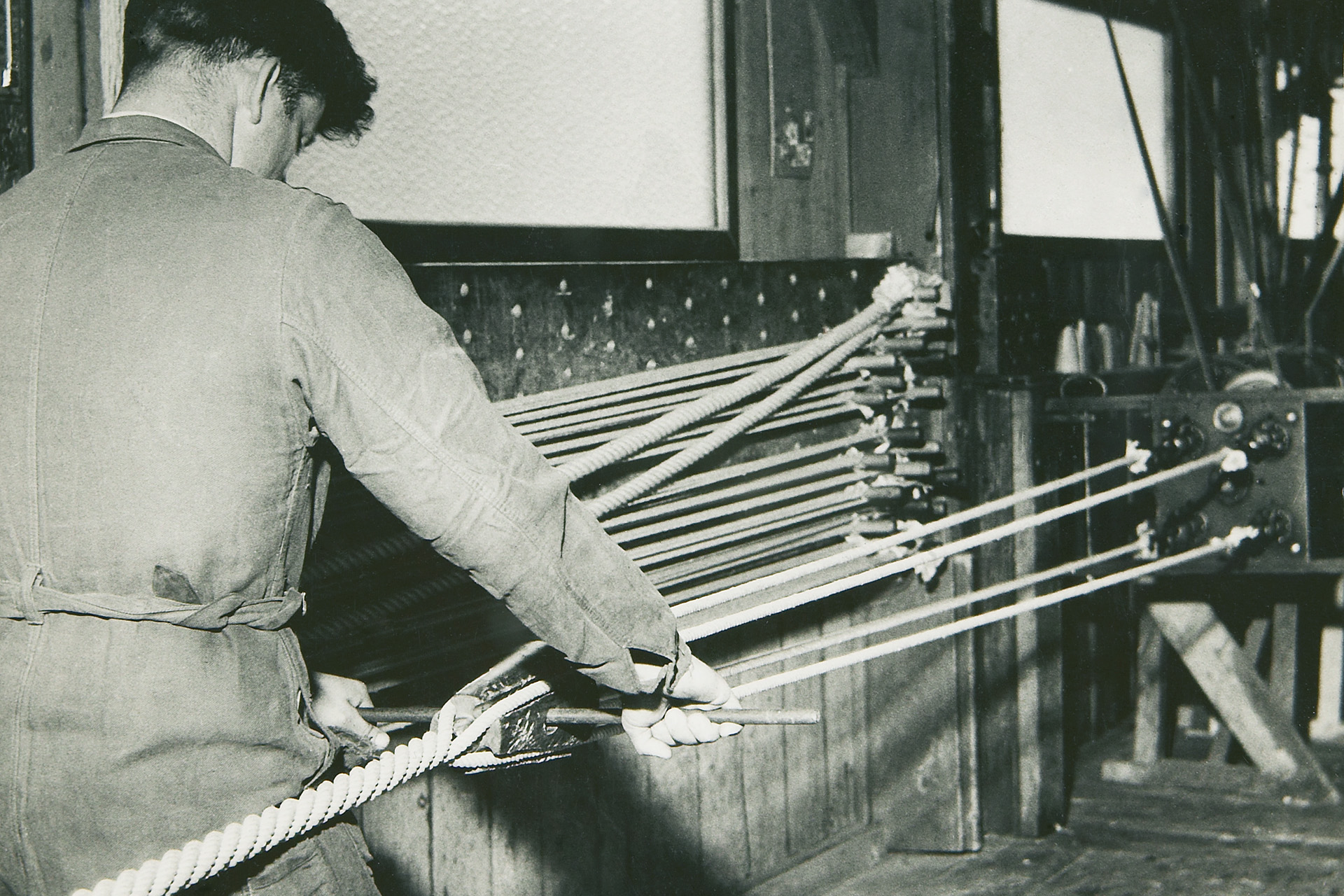 An old photography of a worker producing a fibre rope in the 1950s